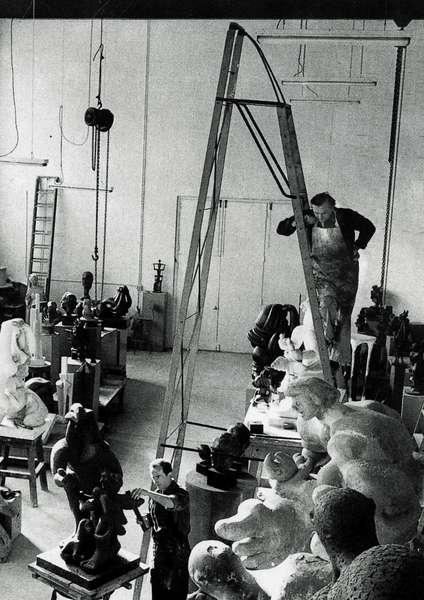 Jacques Lipchitz nel suo laboratorio, su una scala, tra le sculture